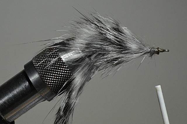 Einige Büschel Haar eines Zonkerstreifens abschneiden und hinter dem Hakenöhr einbinden. Abschlussknoten machen und den Bindefaden abschneiden.